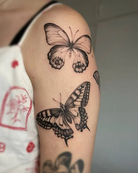 Blackwork Butterflies on Women Upper Arm Tattoo by @crossroads.collective_sa