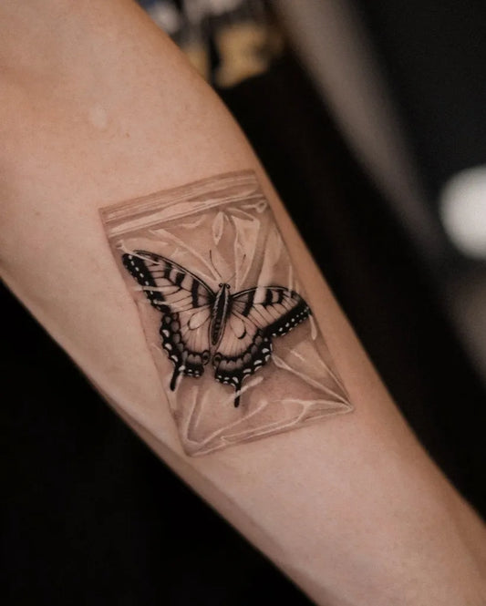 Blackwork Butterfly in Plastic Bag on Women Forearm Tattoo by @dionne.tattoo