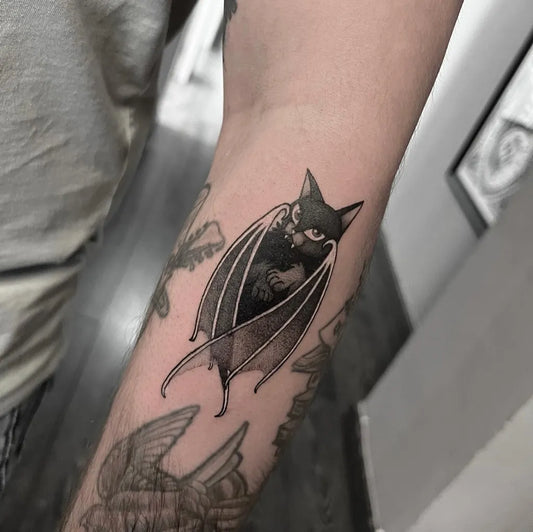 Medium Blackwork Cat with Bat Wings Tattoo on Men Arm by @margolisdark