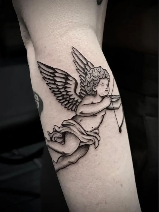 Medium Blackwork Cherub with Bow Tattoo on Women Arm by @animalisticbones