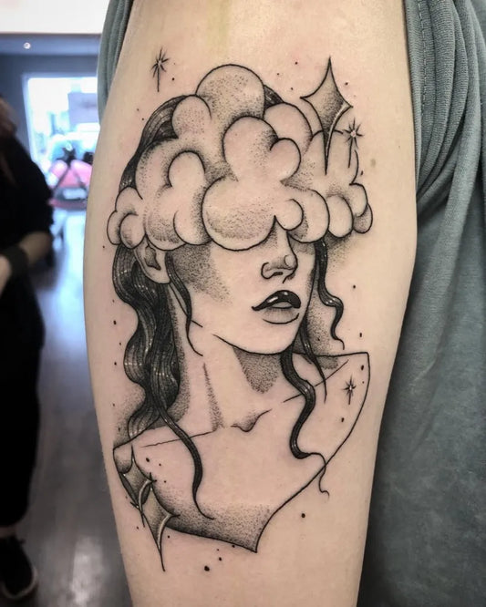 Medium Blackwork Cloud Face Tattoo on Women Bicep by @roogladwelltattoos
