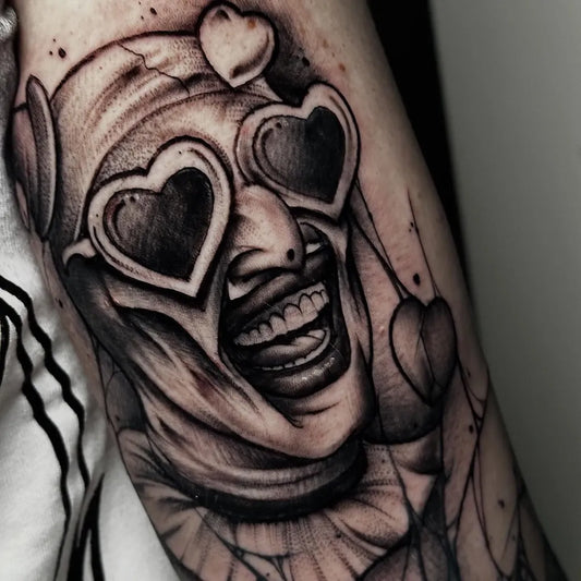 Medium Blackwork Clown with Hearts Horror Tattoo on Men Arm by @no.one.tattoo_