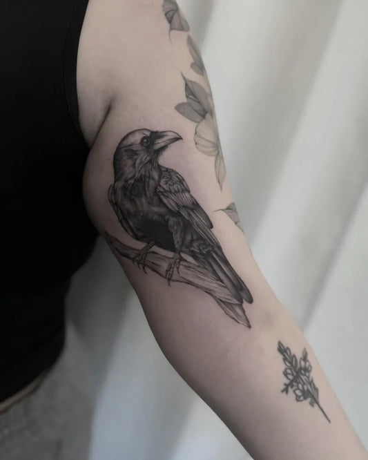 Medium Blackwork Crow Branch Tattoo on Women Arm by @inkedbyjules_