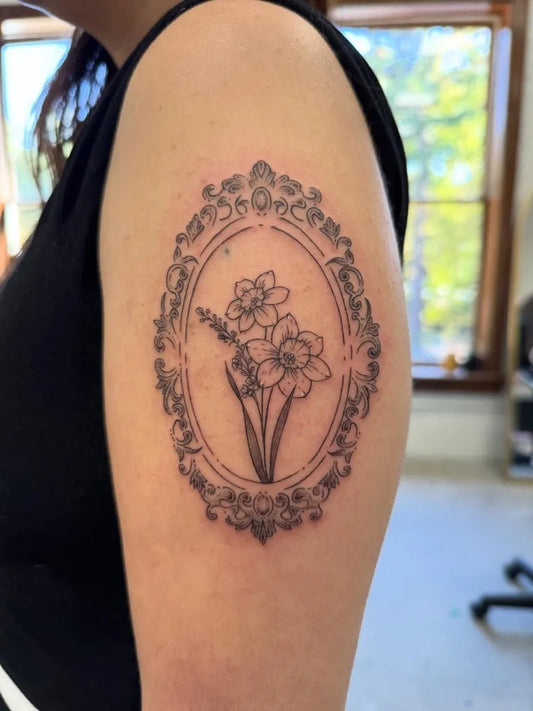 Medium Blackwork Daffodil Frame Tattoo on Women Shoulder by @d00dler.bugtattoos