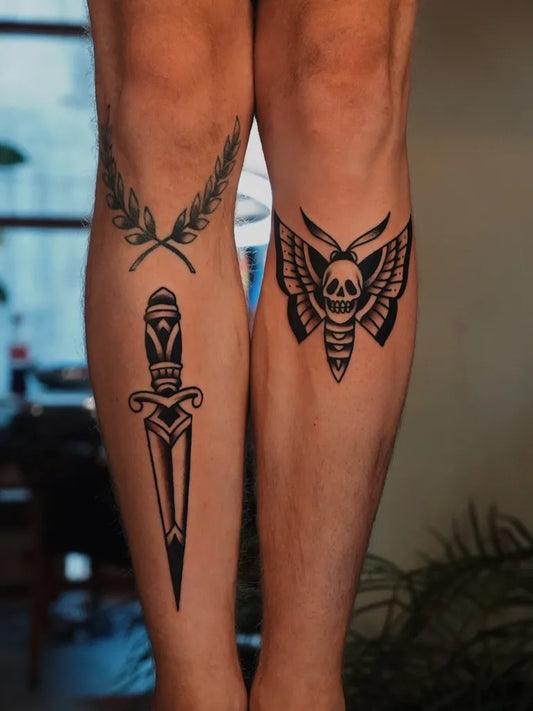 Medium Blackwork Dagger Moth and Laurel Tattoo on Men Legs by @figtree.tattoo.studio