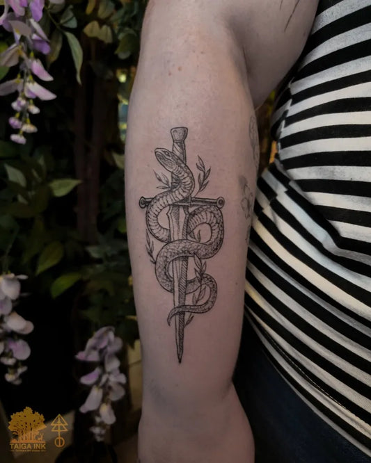 Medium Blackwork Dagger and Snake Tattoo on Women Arm by @taigaink