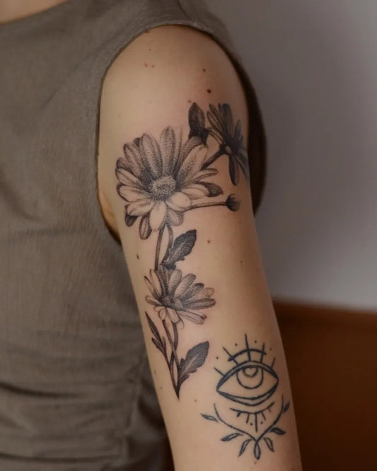 Medium Blackwork Daisy and Eye Tattoo on Women Arm by @laura.tattooed.this