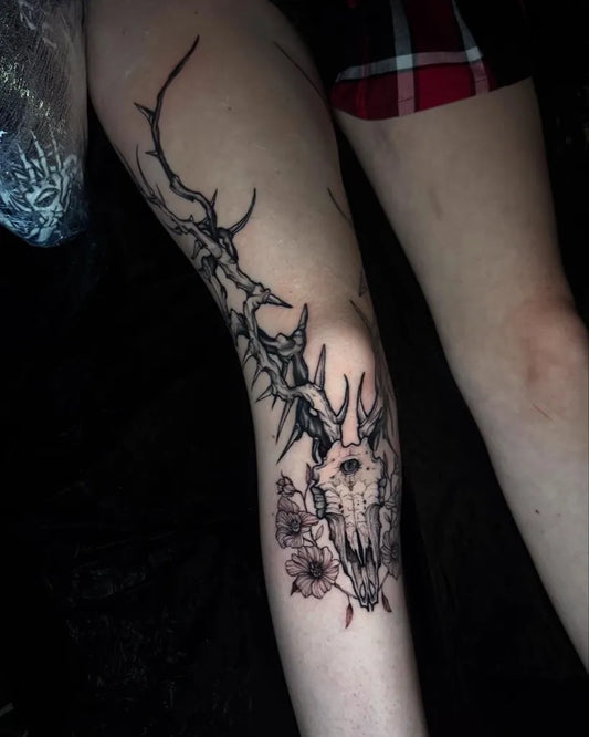 Medium Blackwork Deer Skull with Thorns and Flowers Tattoo on Women Knee by @pretty_inpink_ink