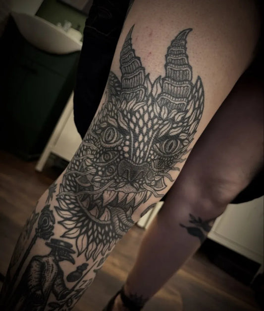 Medium Blackwork Demon Face and Flowers Tattoo on Women Thigh by @digglertattoo