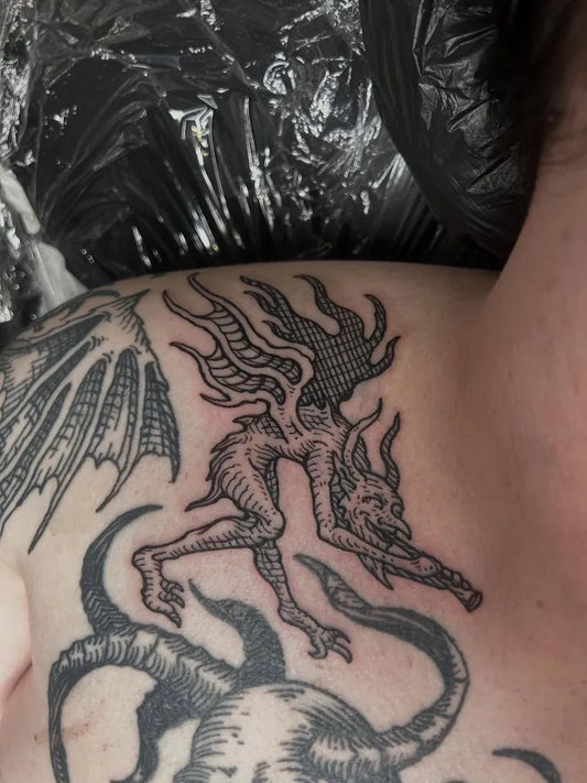 Medium Blackwork Demon with Wings and Flames Tattoo on Women Shoulder by @radiance_tattoo