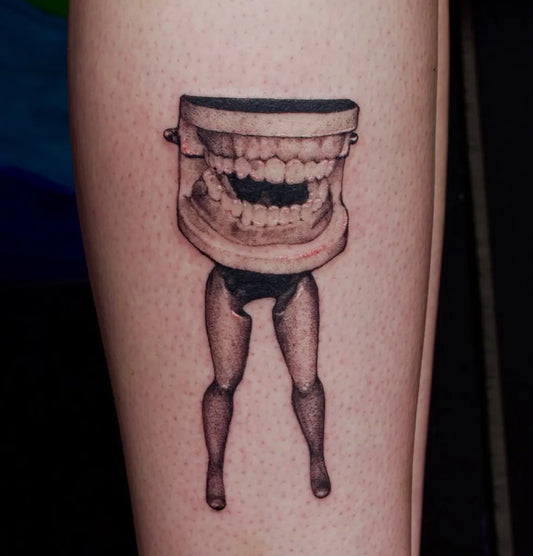 Medium Blackwork Dentures with Legs Horror Tattoo on Women Arm by @creatureoutside