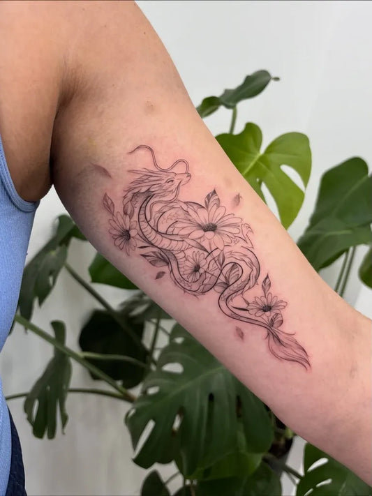 Medium Blackwork Dragon and Daisy Tattoo on Women Arm by @elliehavis.tattoo