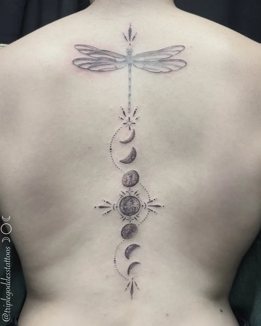Medium Blackwork Dragonfly and Moon Phases Tattoo on Women Back by @triplegoddesstattoos