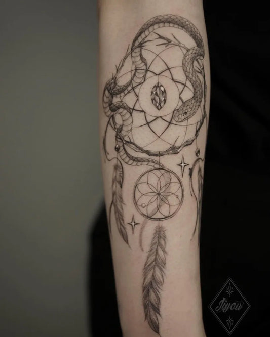 Medium Blackwork Dream Catcher with Snakes Tattoo on Women Arm by @jiy.u_ink