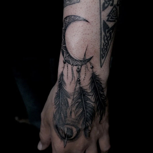 Medium Blackwork Dreamcatcher Feathers Tattoo on Men Wrist by @put.tattoo.nakhonsawan