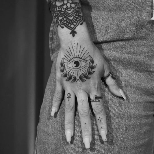 Medium Blackwork Evil Eye Laurel on Women Hand Tattoo by @inked.by.shenae