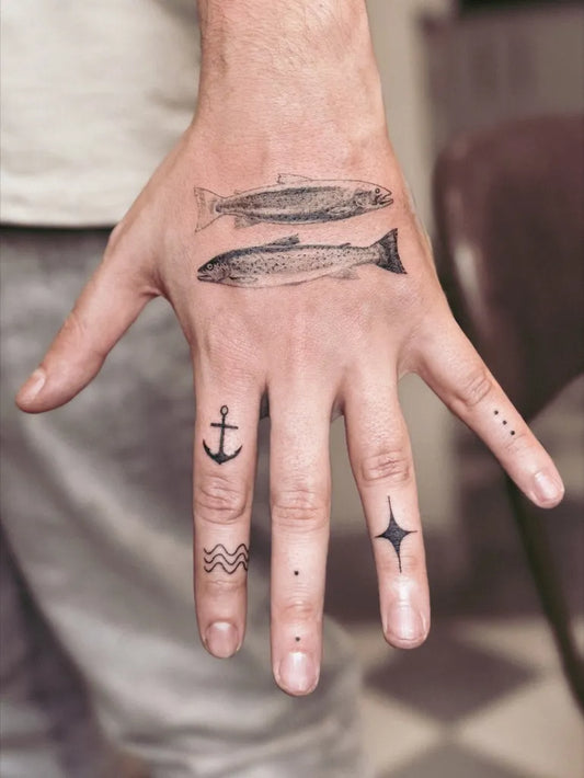 Medium Blackwork Fish and Anchor Tattoo on Men Hand by @joan.jaguar