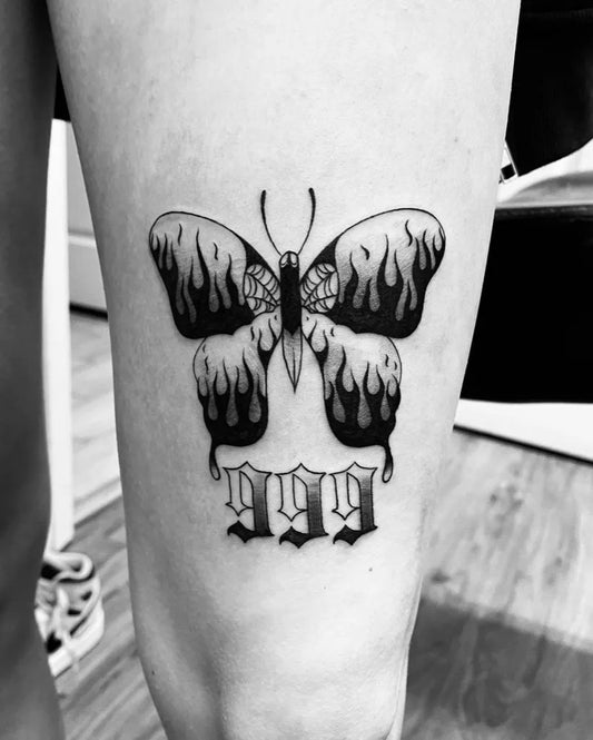 Medium Blackwork Flame Butterfly with Flames and 999 Tattoo on Women Thigh by @tattoosbylucyx