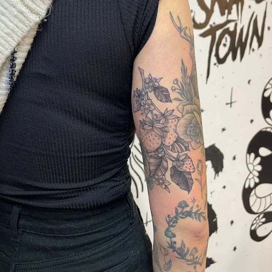 Medium Blackwork Floral and Strawberry Tattoo on Women Bicep by @laurenbrice_tattoos