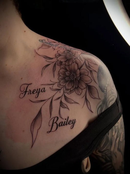 Medium Blackwork Flower and Names Tattoo on Women Shoulder by @tattoosbypheebs