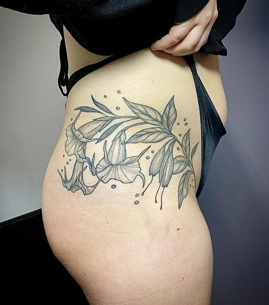 Medium Blackwork Flowers and Leaves Tattoo on Women Hip by @ophiuchus.tattoo
