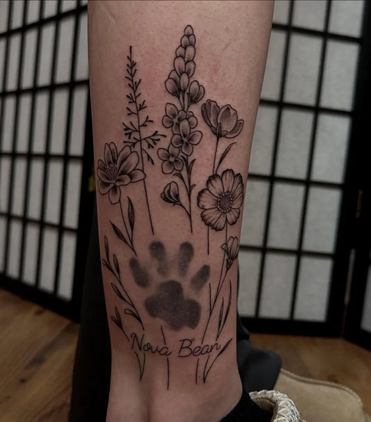Medium Blackwork Flowers and Paw Print Tattoo on Women Leg by @manic.art