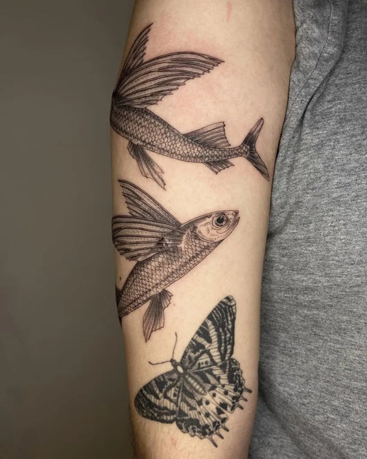 Medium Blackwork Flying Fish and Butterfly Tattoo on Men Upper Arm by @ulaluart