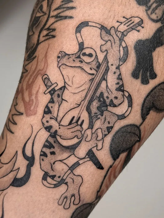 Medium Blackwork Frog Musician Tattoo on Men Arm by @cejaymedio_tattoo