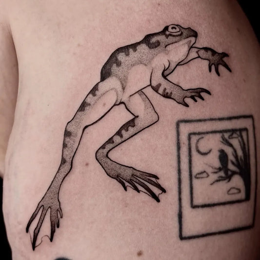 Medium Blackwork Frog and Polaroid Tattoo on Women Shoulder by @rarexbeef