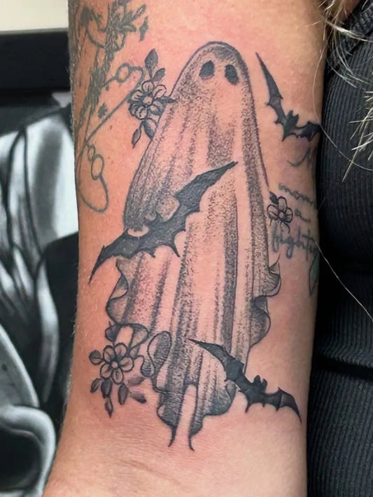 Medium Blackwork Ghost Bats Flowers Tattoo on Women Arm by @porkchoptattoos_myrtlebeach