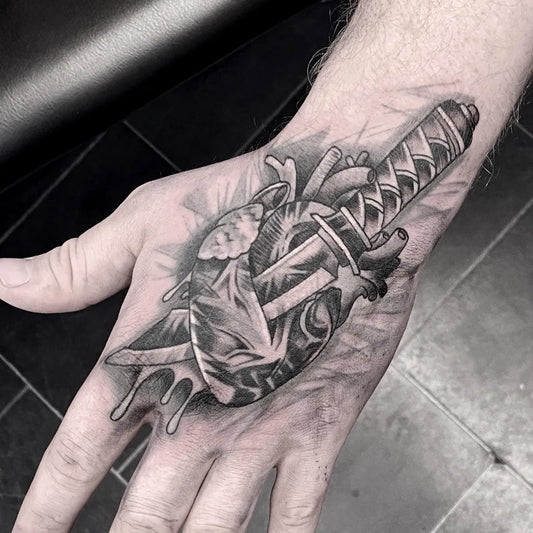Medium Blackwork Heart and Knife Tattoo on Men Hand by @lemondragontattoo
