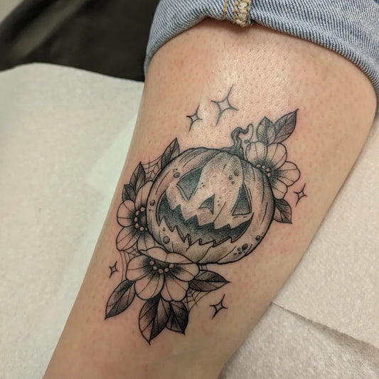 Medium Blackwork Jack o lantern and Flowers Halloween Tattoo on Women Thigh by @adelemagpies