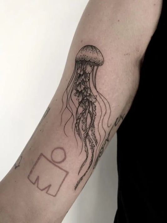 Medium Blackwork Jellyfish and Ironman Tattoo on Women Arm by @inked_by_alice