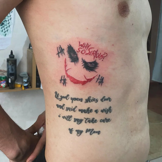 Medium Blackwork Joker Face and Text on Men Rib Tattoo by @tatouagediabloocasablanca