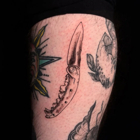 Medium Blackwork Knife and Sun Tattoo on Men Thigh by @mothbug.art