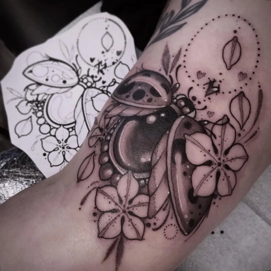 Medium Blackwork Ladybug and Flowers Tattoo on Women Arm by @siknaktattoo