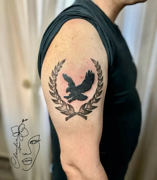 Medium Blackwork Laurel Wreath Eagle Tattoo on Men Upper Arm by @claudia86_ink