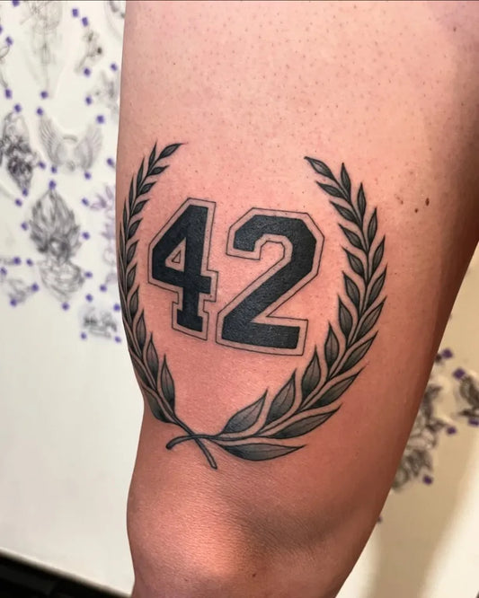 Medium Blackwork Laurel Wreath and 42 Tattoo on Men Thigh by @pol_parkinson