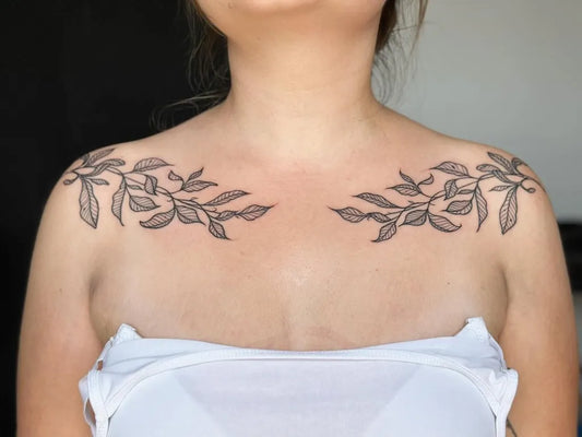 Medium Blackwork Leaves Tattoo on Women Collarbone by @pelc.tt