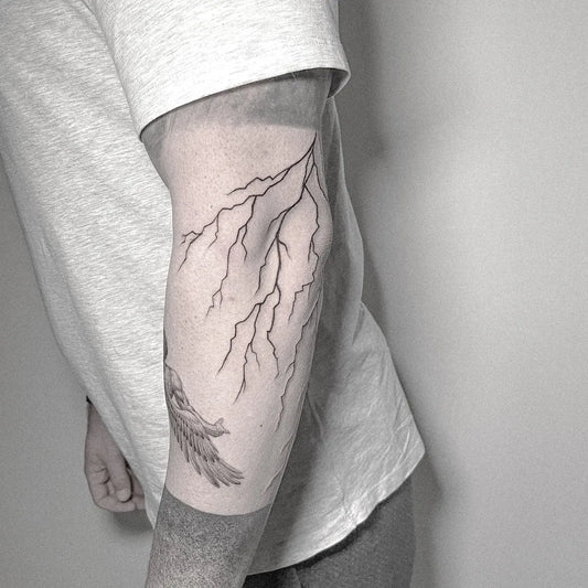 Medium Blackwork Lightning Bolt and Wing Tattoo on Men Arm by @inshvvn