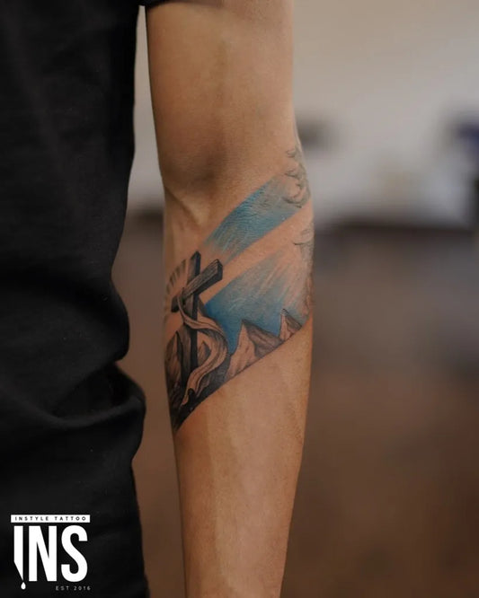Medium Blackwork Mountain Cross Tattoo on Men Arm by @instyletattoostudio