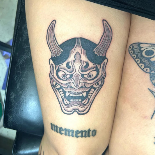 Medium Blackwork Oni Mask and Butterfly on Women Thigh Tattoo by @carpediemtattoomontebello