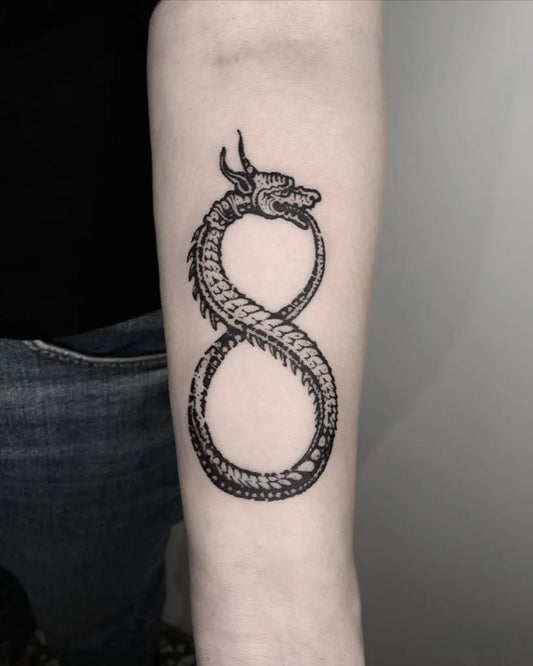 Medium Blackwork Ouroboros Tattoo on Women Arm by @kajetankarczewski