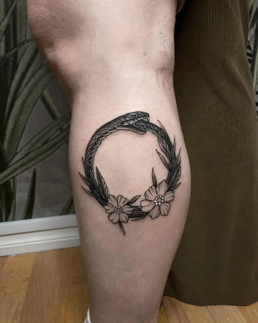 Medium Blackwork Ouroboros Wreath Tattoo on Women Thigh by @caroljtattoo