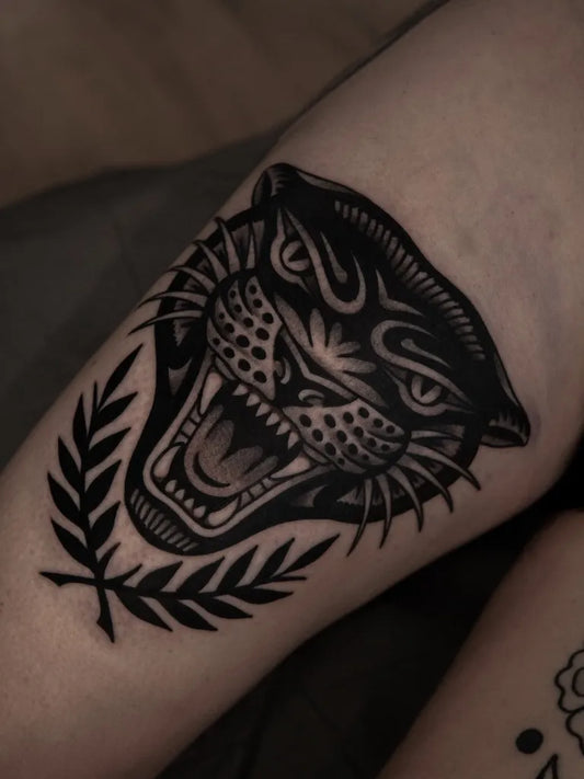 Medium Blackwork Panther Laurel Women Thigh Tattoo on Women Thigh by @yuri.tattoos