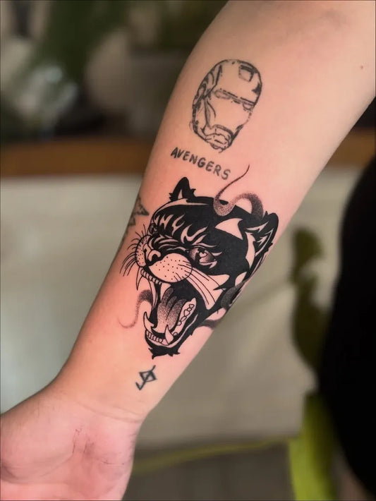 Medium Blackwork Panther and Iron Man Tattoo on Women Arm by @maquilin