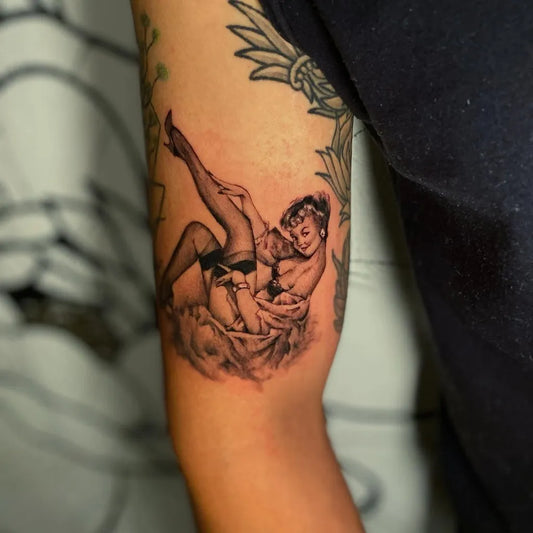 Medium Blackwork Pin Up Girl and Cherub Tattoo on Women Arm by @elenagarcia.tattoo