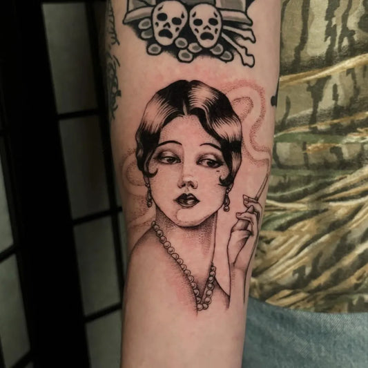 Medium Blackwork Pin Up Girl with Cigarette and Skulls Tattoo on Women Arm by @bailey.tattoos