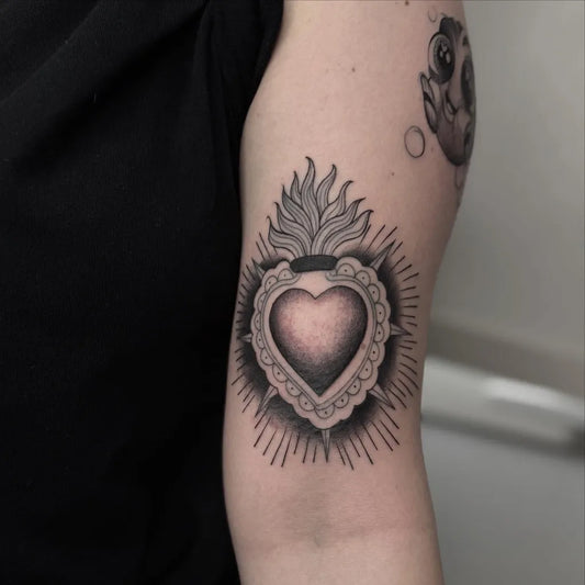 Medium Blackwork Sacred Heart with Flames Tattoo on Women Upper Arm by @valucciafragalatattooartist