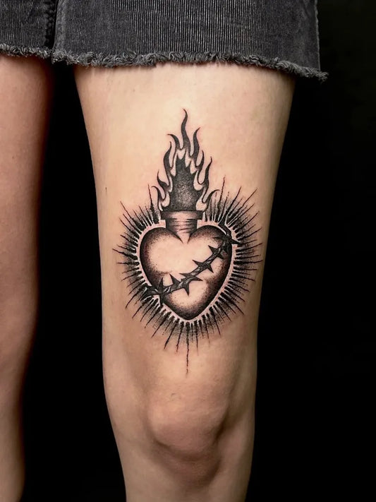 Medium Blackwork Sacred Heart with Flames and Crown of Thorns Tattoo on Women Thigh by @inkedraven.tattoo